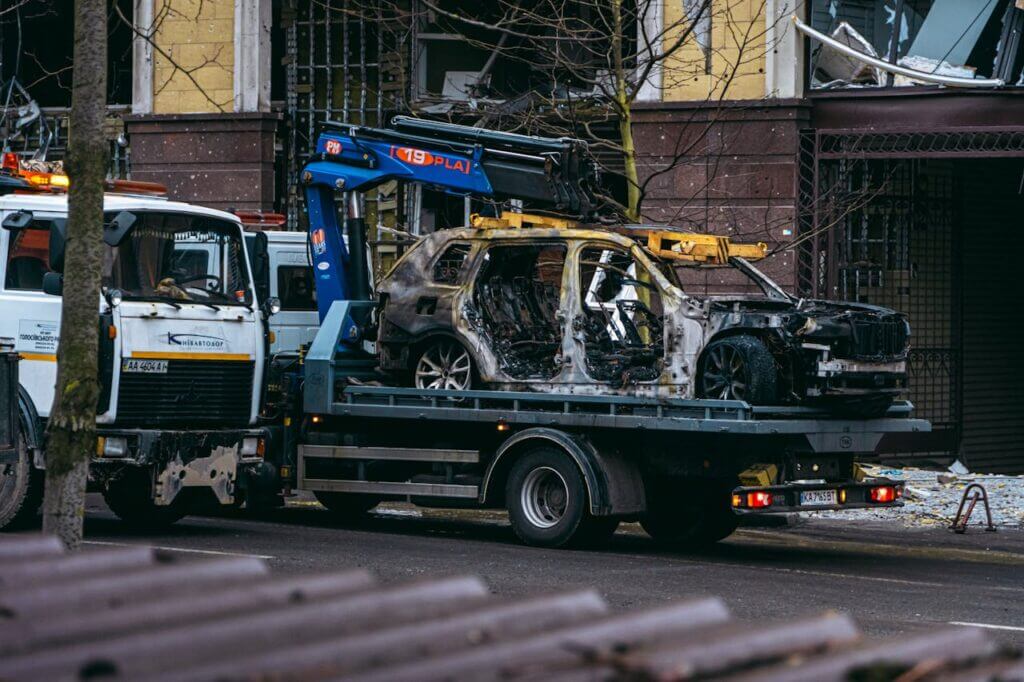 Une voiture brûlée est remorquée dans une rue de Ivry-sur-seine 94, soulignant les conséquences du conflit.